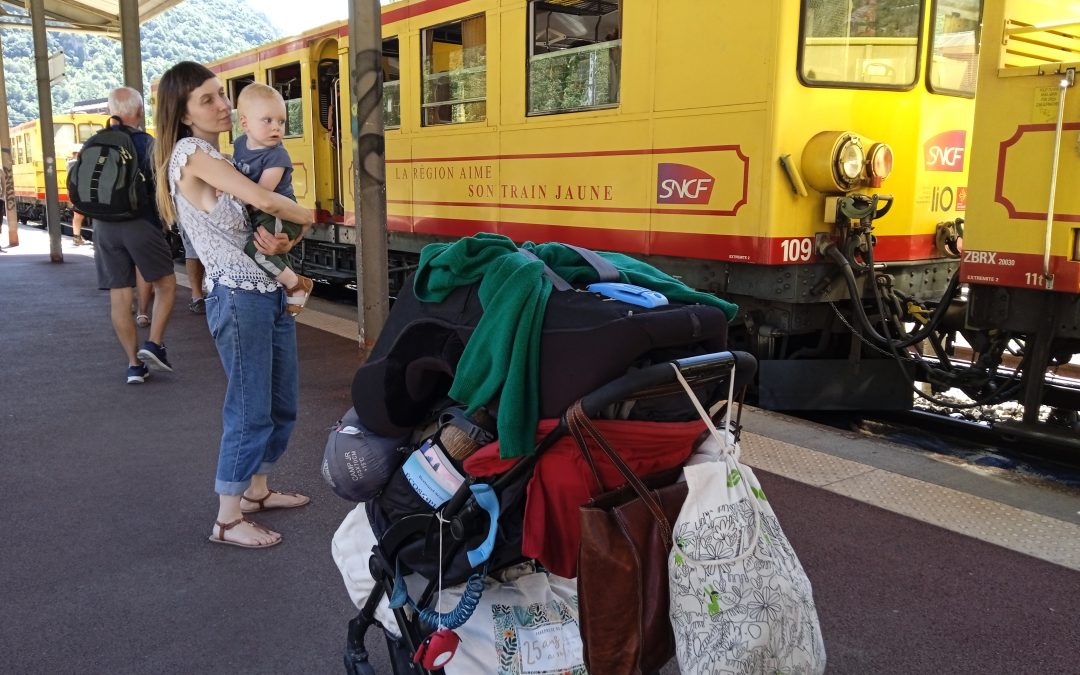 Nour, sa maman et les bagages devant le train jaune